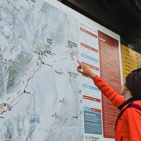Wanderin orientirt sich anhand der Überischtskarte  | © TVB Wipptal / Johannes Bitter