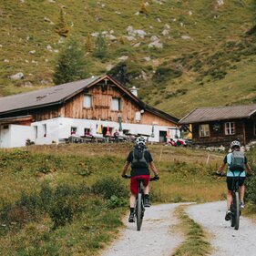 Zwei Radfahrer auf einem Mountainbikeweg fahren zu einer Alm  | © TVB Wipptal | Johannes Bitter