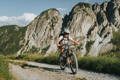 Eine Radfahrerein bei der Auffahrt auf einem Mountainbikeweg | © TVB Wiptal | Johannes Bitter
