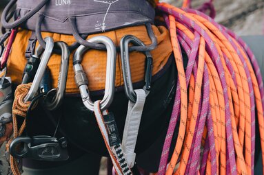 Nahaufnahme einer Person von hinten, die einen Klettergurt - ausgestattet mit Seilen und trägt.  | © TVB Wipptal | Johannes Bitter