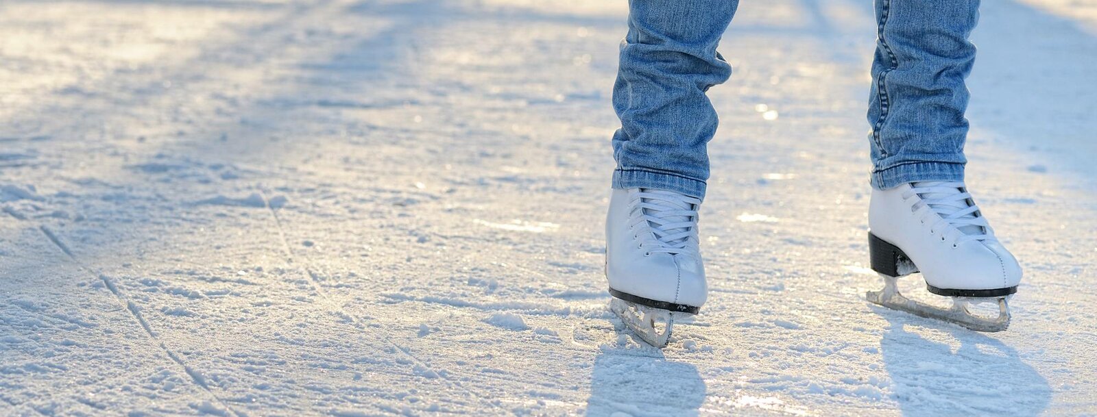 Zwei Beine mit Eislaufschuhen am Eis | © Bigstock