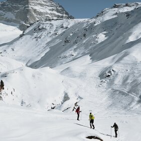 Eine Gruppe von drei Personen wandert durch eine verschneite Winterlandschaft  | © TVB Wipptal | Johannes Bitter