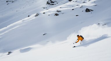 Ein Skifahrer zieht seine Schwünge im Pulverschnee im Wildlahnertal im Bergsteigerdorf Schmirn | © TVB Wipptal | Johannes Bitter