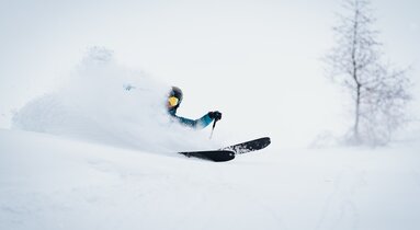 Ein Skifahrer taucht bei der Abfahrt tief in den Pulverschnee ein | © TVB Wipptal | Johannes Bitter
