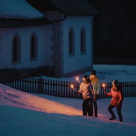 Drei Personen in Winterkleidung gehüllt mit brennenden Fackeln in der Hand | © TVB Wipptal / Johannes Bitter