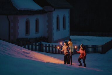 Drei Personen in Winterkleidung gehüllt mit brennenden Fackeln in der Hand | © TVB Wipptal / Johannes Bitter