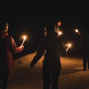 Fackelwanderung zur Kalten Herberge mit 4 Personen die Fackeln in den Händen halten | © Tourismusverband Wipptal | Johannes Bitter
