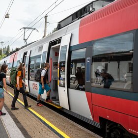 Freunde mit Wanderrucksack steigen in die S-Bahn in Matrei ein. | © TVB Wipptal - Helena Beermeister