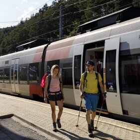 Ein Pärchen im Wanderoutfit steigt im Bahnhof aus der S-Bahn | © Tirol Werbung