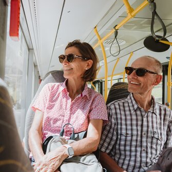 Päärchen sitzt im Bus und betrachtet die Natur lächelnd aus dem Fenster | © Tourismusverband Wipptal | Johannes Bitter