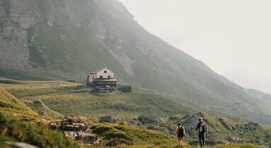 Zwei Wanderer auf einem Wanderpfad zur Berghütte | © TVB Wipptal | Johannes Bitter