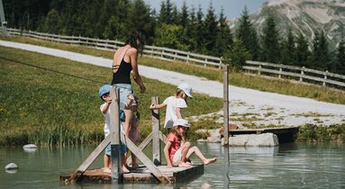 Frau und drei Kinder stehen auf einem Floss und zieht sich mit einem Seil auf die andere Seite | © TVB Wipptal | Johannes Bitter