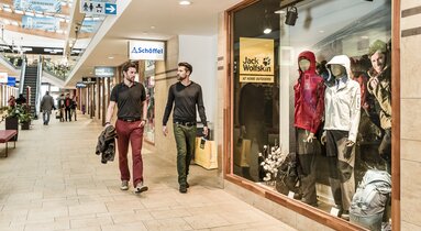 Ein Mann und eine Frau schlendern durch das Einkaufszentrum | © Outlet Center Brenner
