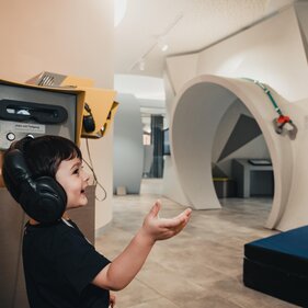 Ein Kind mit Kopfhörern in den BBT Tunnelwelten in Steinach | © TVB Wipptal / Johannes Bitter