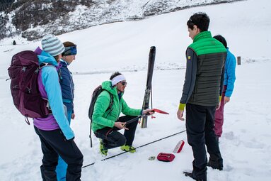 Bergführer Thomas erklärt die Sicherheitsausrüstung, die jeder Skitourengeher dabei haben sollte | © TVB Wipptal | Judith Hammer