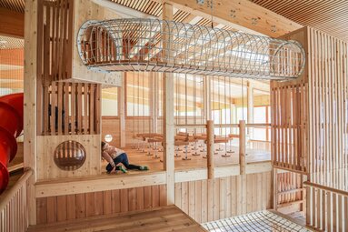 Kind beim Spielen im Indoor-Holzspielplatz beim JUFA Hotel Wipptal | © Ewelina Herzog