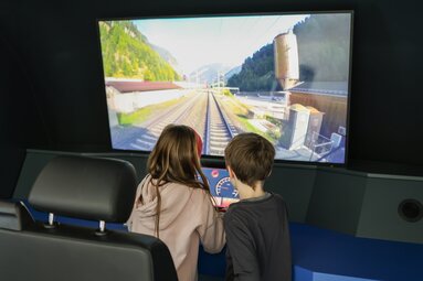 Kinder beim Spielen am Bahnsimulator im BBT Infocenter Tunnelwelten in Steinach | © Ewelina Herzog