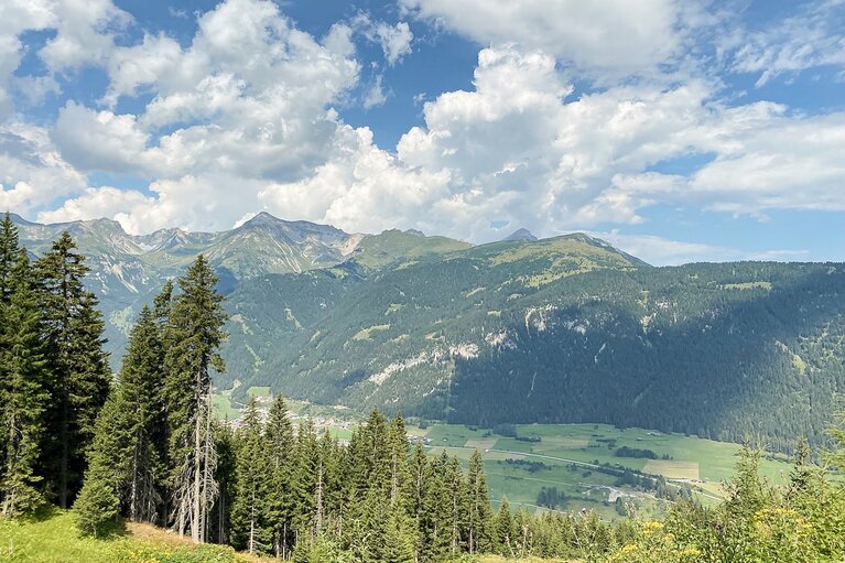 Ausblick von oben über ein Tal mit einer Gebirgskette im Hintergrund | © Daniela Plattner