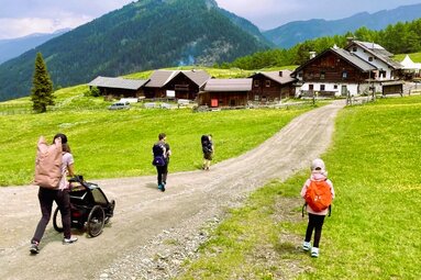Eine Frau mit 3 Kindern und Kinderwagen kurz vor der Sattelbergalm | © TVB Wipptal / Daniela Achmüller