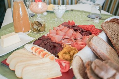 Ein gedeckter Tisch mit Jausenplatte, Brotkorb und  | © TVB Wipptal