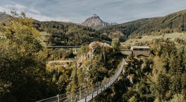 Blick über die Hängebrücke auf Burg Trautson, im Hintergrund Serles | © TVB Wipptal | Victoria Hörtnagl