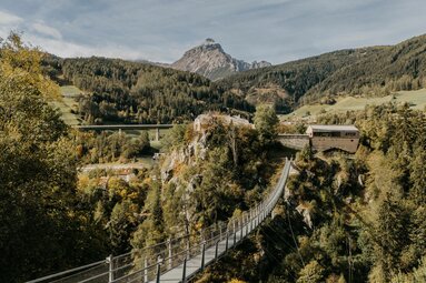 Blick über die Hängebrücke auf Burg Trautson, im Hintergrund Serles | © TVB Wipptal | Victoria Hörtnagl