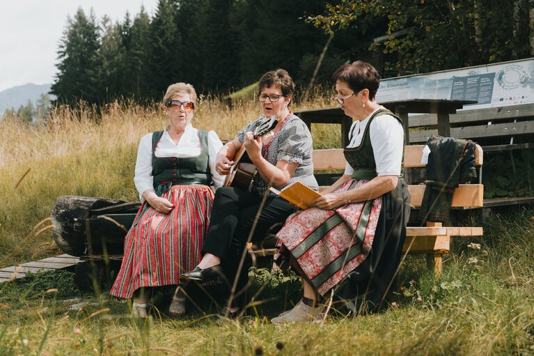 Drei Frauen sitzen auf einer Bank und musizieren gemeinsam | © Tourismusverband Wipptal | Johannes Bitter  
