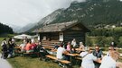 Leute sitzen gemütlich auf Bierbänken vor einem Stadl | © TVB Wipptal | Johannes Bitter