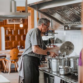 Der Koch am Herd in der Hüttenküche auf der Geraerhütte | © TVB Wipptal / Johannes Bitter