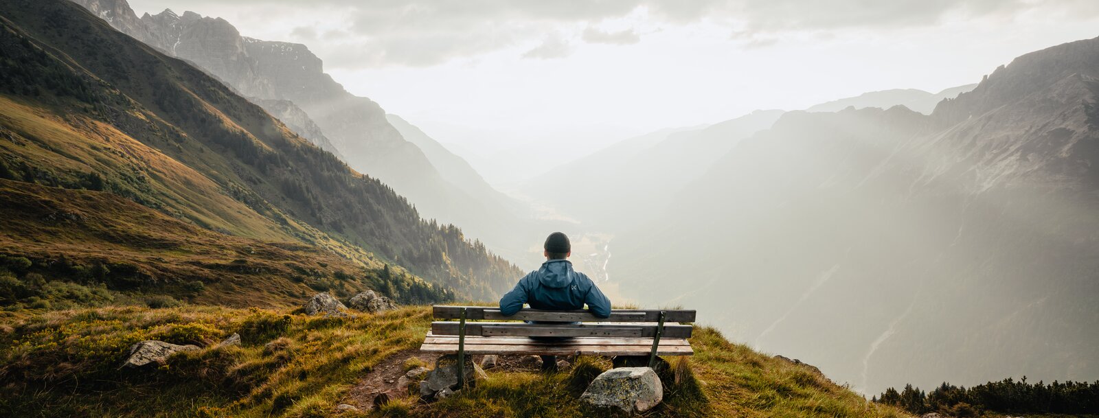 Mann sitzt auf Bank am Berg und genießt die Aussicht | © Tourismusverband Wipptal | Johannes Bitter