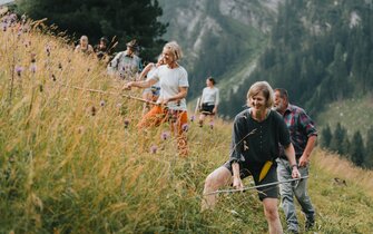 Gruppe von Menschen beim Sensenmähen | © TVB Wipptal | Johannes Bitter